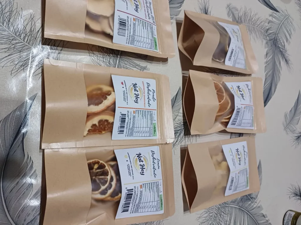 Getrocknete Zitronenscheiben in transparenter Verpackung auf hellem Holzuntergrund – natürlich getrocknet, gleichmäßige Scheiben, hochwertige Produktqualität