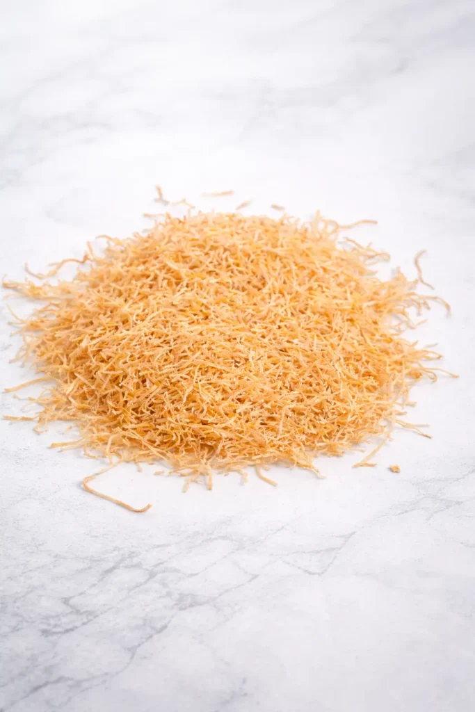 Carotte râpée déshydratée de couleur orange clair sur fond blanc, texture fine et régulière, présentation produit professionnelle B2B